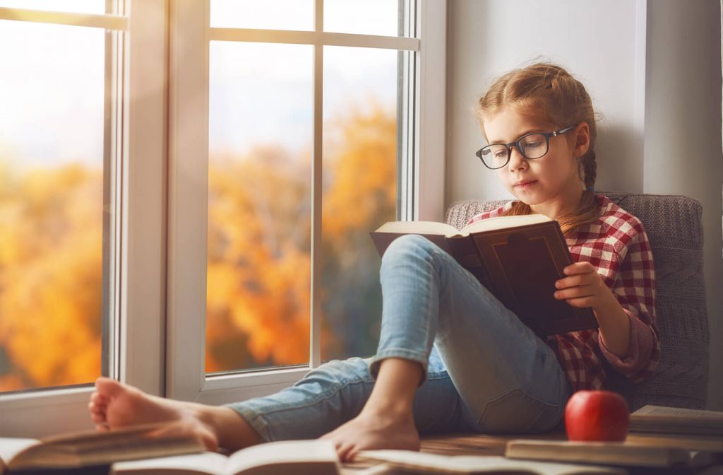 Girl reading in bay window