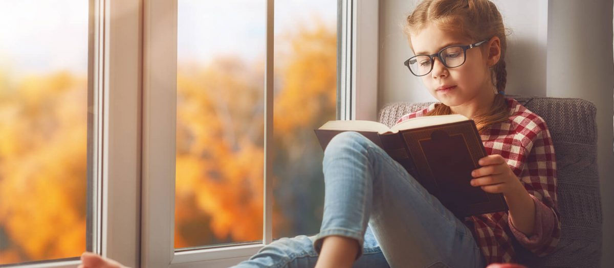 Girl reading in bay window